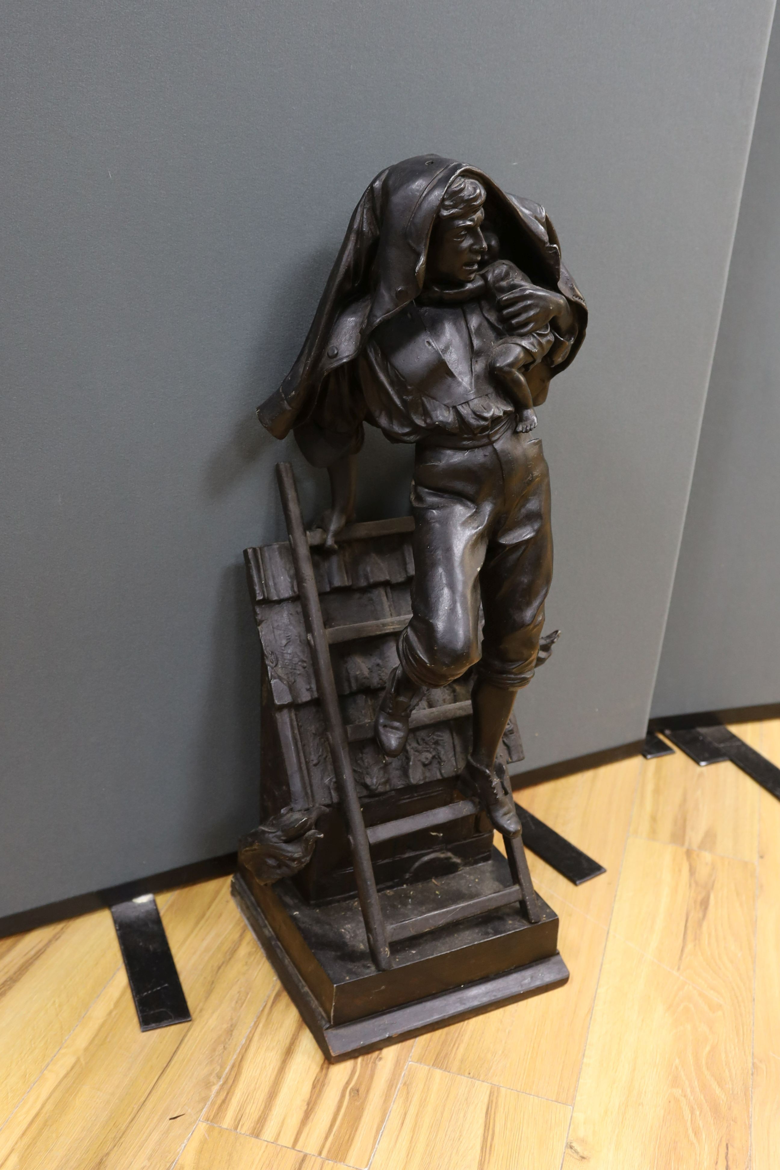 A cast spelter figure of a fireman performing rescue of a child, 81 cms high.